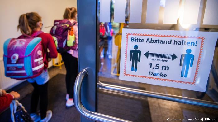 Crianças entram num edifício escolar em Mecklemburgo-Pomerânia Ocidental, o primeiro estado alemão a retomar as aulas integralmente.