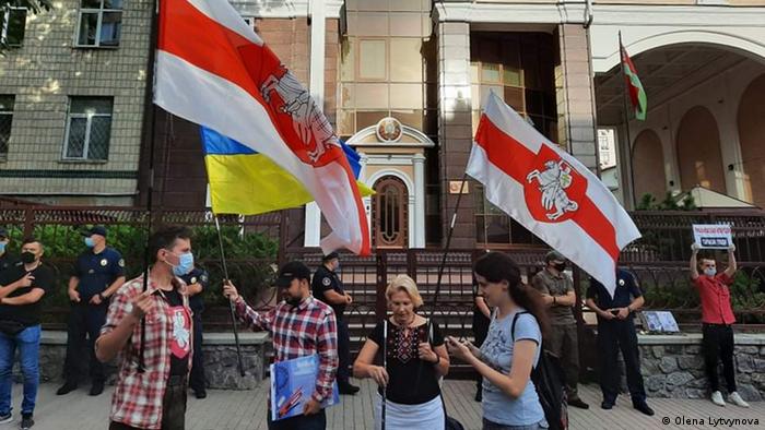 Jovens carregam bandeiras diante de prédio público
