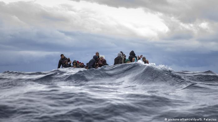 Men sitting in overcrowded wooden boat off Libya (picture-alliance/dpa/S. Palacios)