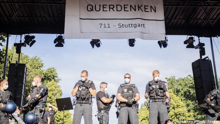 Policemen standing under a banner at the demonstration in Berlin on August 1 (picture-alliance/dpa/C. Soeder)