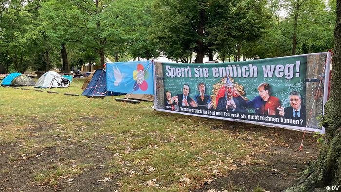 Tents and banners in park in Berlin (DW)