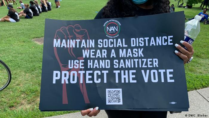 Manifestante junto al Memorial a Lincoln con un cartel en el que se lee: Mantenga la distancia social, lleve tapabocas, use desinfectante de manos y proteja el voto.
USA | Anti-Rassismus-Kundgebung in Washington (DW/C. Bleiker)