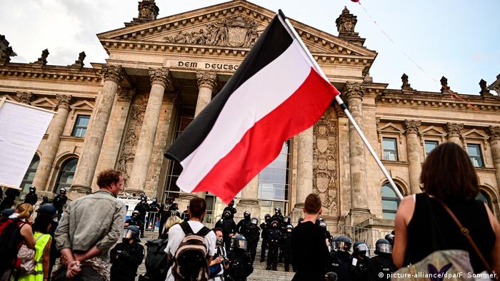 Manifestantes e policiais em frente à fachada do Reichstag em Berlim