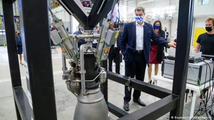 Премьер-министр Баварии Маркус Зёдер осматривает ракетный двигатель, разработанный комапнией Isar Aerospace