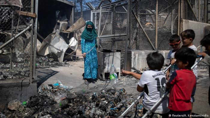 Woman and children in burned-out Moria camp (Reuters/A. Konstantinidis)