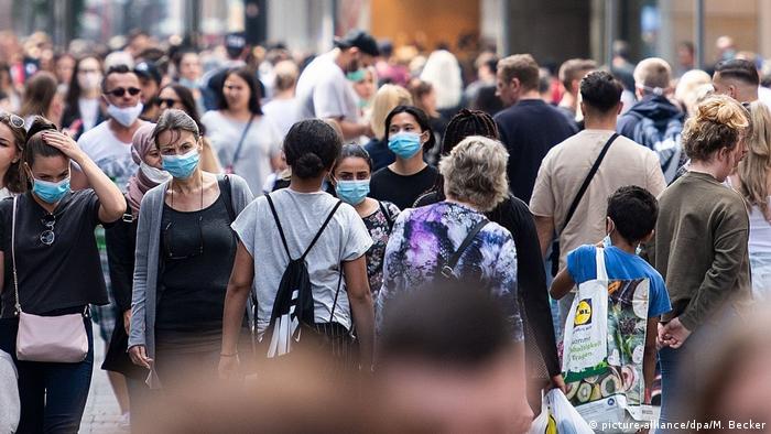 People with facemasks in pedestrian shopping street (picture-alliance/dpa/M. Becker)