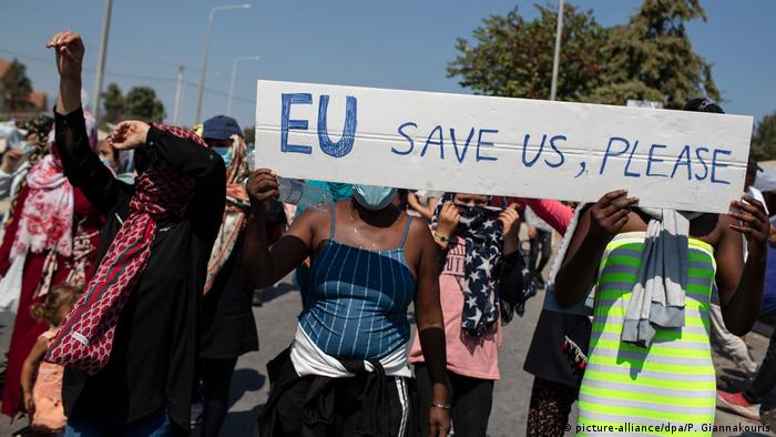 Asylum-seekers on Lesbos at a protest hold a sign that reads EU save us, please (picture-alliance/dpa/P. Giannakouris)