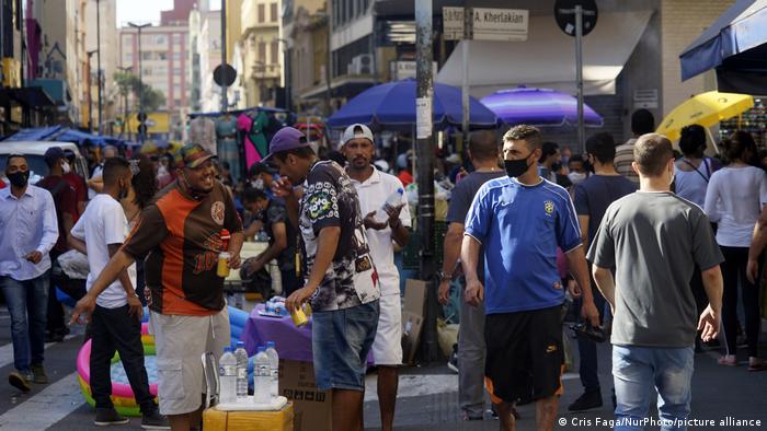 Pessoas em rua movimentada de São Paulo em meio à pandemia