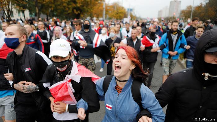 Column of protesters with white-red-white flags
