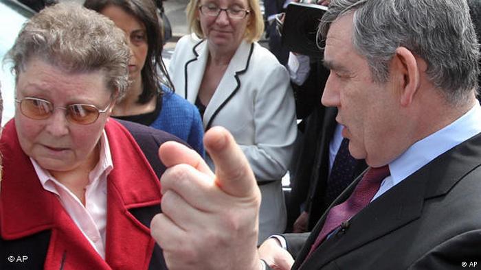 Gordon Brown points his finger at the camera while speaking to a woman who looks away (AP)
