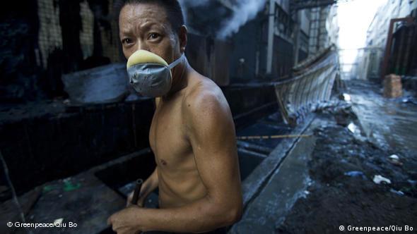Trabajador de una fábrica de ropa vaquera en China. No tiene protección.